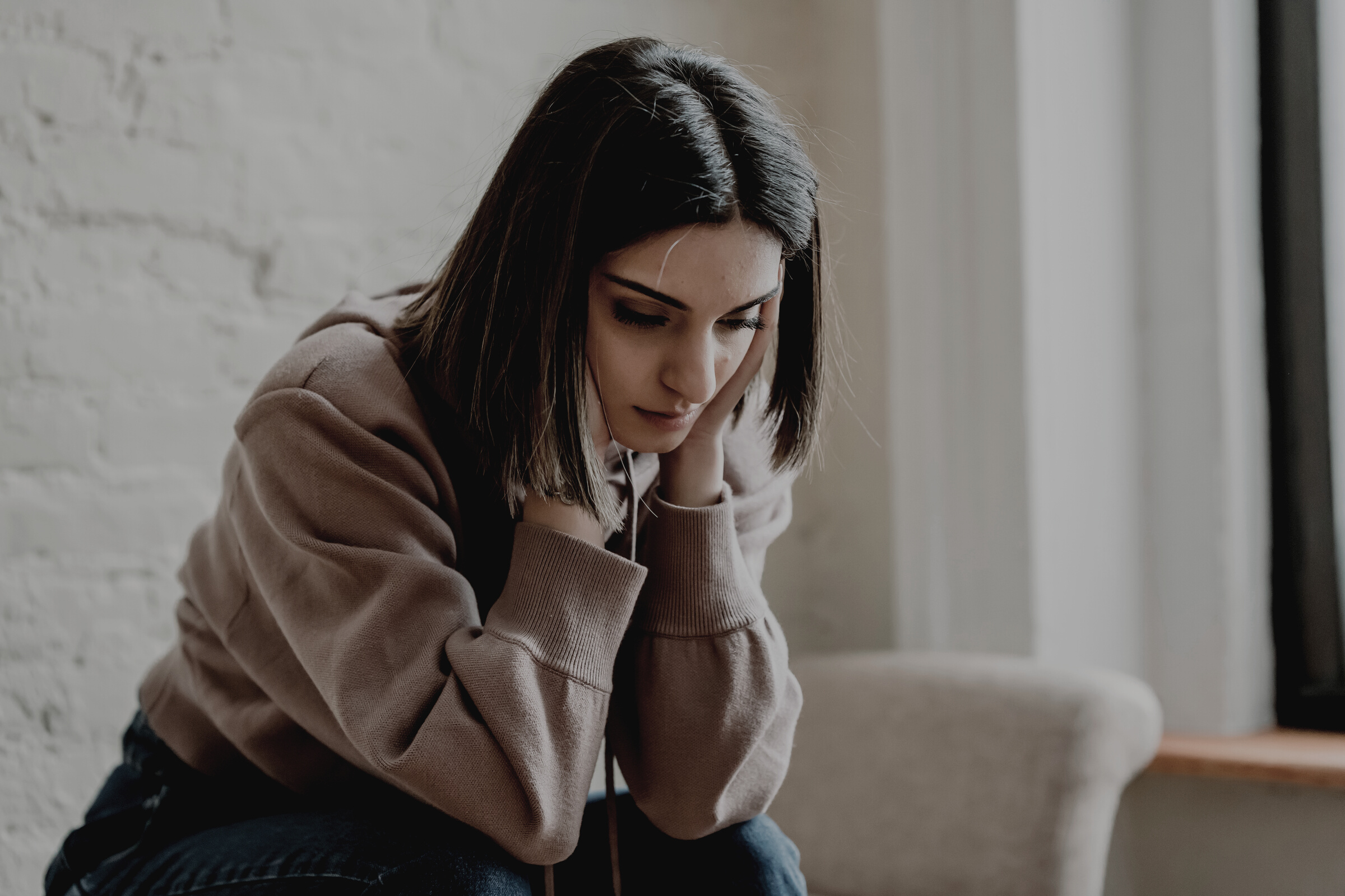 Sad woman sitting on couch